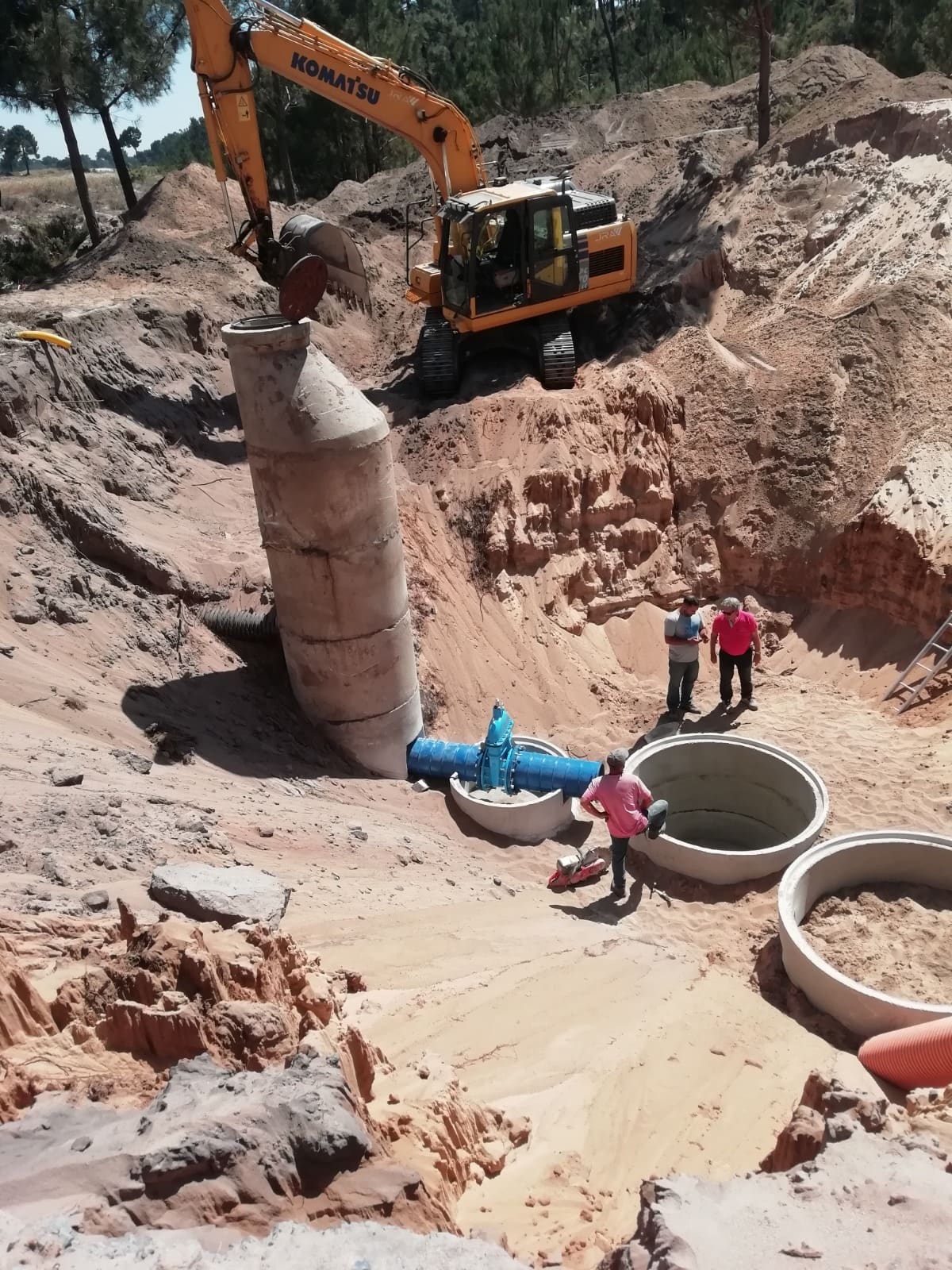 Rede de saneamento e conduta em obra com escavadora